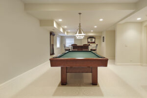 A finished basement with a pool table.